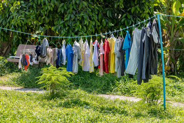 The laundry is dried on a rope in the garden. Drying clothes in the backyard.