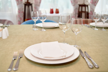 Table setting with empty white plate, napkin and cutlery on table, copy space. Menu mockup, place...