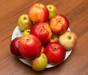 Plate with red apples on the table