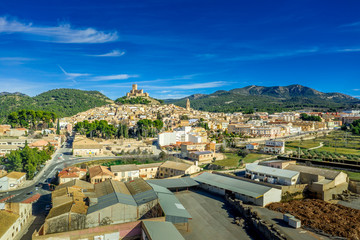 Aerial view of Biar castle in Valencia province Spain with donjon towering over the town and concentric walls reinforced with semi circular towers on a sunny day with blue sky