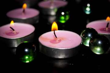 Obraz na płótnie Canvas Lighted decorative candles on a black background