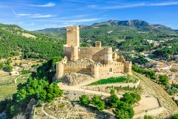 Aerial view of Biar castle in Valencia province Spain with donjon towering over the town and concentric walls reinforced with semi circular towers on a sunny day with blue sky