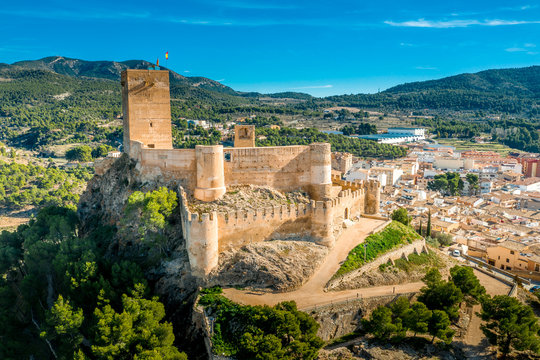 Aerial view of Biar castle in Valencia province Spain with donjon towering over the town and concentric walls reinforced with semi circular towers on a sunny day with blue sky