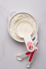 cup with flour on a white background close-up top view