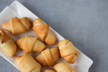 Homemade baking. Curls with jam on a white plate.