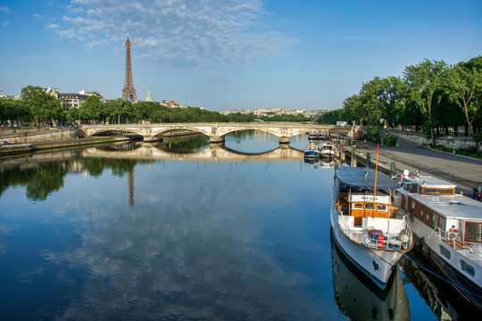 PARIS, FRANCE - MAY 26, 2018: View of the Bridge of the Invalides and the Eiffel Tower. Walk through Pont Alexandre III. Boats on the pier