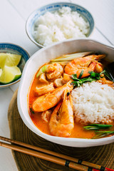 Tasty Tom Yam with shrimp and rice, spicy Thai soup, close-up