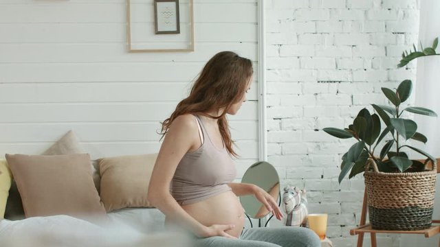 Closeup expectant mother suffering nausea bedroom. Pregnant trying drink home.
