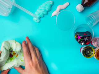 Components to make slime. Child education concept. On blue surface slime, toothpaste, shaving foam,...