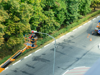 The specialist performs work on replacing old lamps on lampposts with new led lamps.