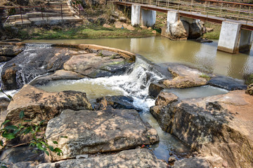 Small water reservoir in stone mountain with bridge for communication from one side to another.