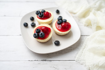 Mini cheesecakes with cherry and blueberry topping, sweet summer treat