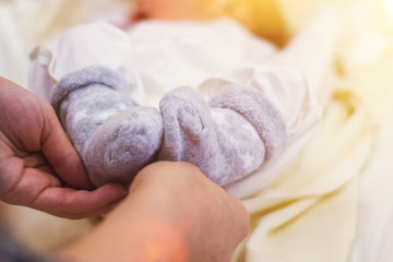 feet of a newborn baby in the hands of parents. The concept of love, healthy childbirth and happy young parents
