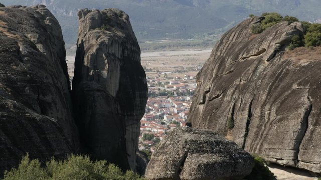Rock formations above Greek town on Kalabaka 4K tilting video