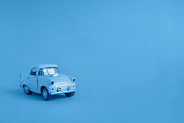 Blue toy car on the road on a classic blue color background 