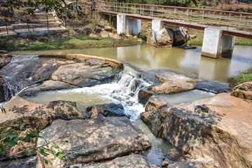Small water reservoir in stone mountain with bridge for communication from one side to another.