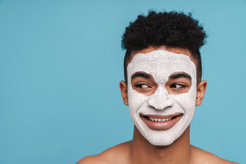 Photo of african american man in facial cosmetic mask looking aside