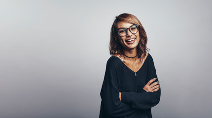 Fototapeta premium Smiling woman standing with arms crossed