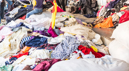 A pile of different used second hand clothes selling at a flea market in Thailand