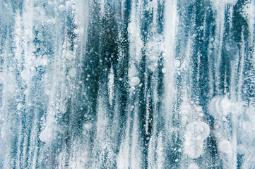 Fototapeta na wymiar Blue ice with air bubbles in the frozen lake. Macro image. Winter nature background