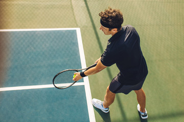 Tennis player with racket ready to serve