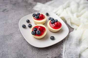 Mini cheesecakes with cherry and blueberry topping, sweet summer treat
