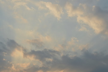 The light of the rising sun in the morning surrounded by clouds.