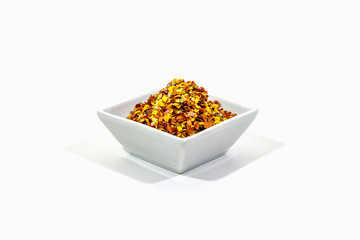 Hot seasoning in plate isolated on white background. Mix of different spices and sea salt. Traditional ingredient for cooking Italian food