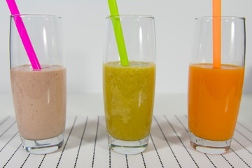three smoothie cocktails on a white table. Healthy eating