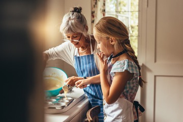 Granny and kid making cup cakes