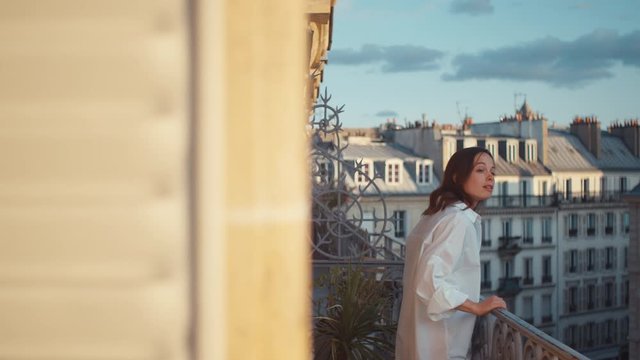 Attractive girl in a white shirt on a balcony in Paris