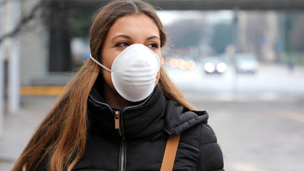 COVID-19 Pandemic Coronavirus Woman in city street wearing face mask protective for spreading of disease virus SARS-CoV-2. Girl with protective mask on face against Coronavirus Disease 2019.