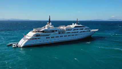Obraz na płótnie Canvas Aerial drone photo of luxury mega yacht docked in Mediterranean destination with deep blue wavy sea