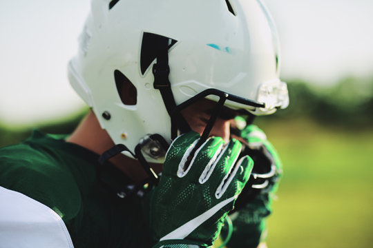 American football player adjusting his helmet during practice
