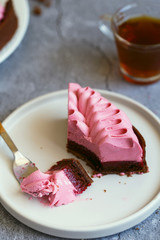 A slice of cake in the process of eating with a dessert fork.