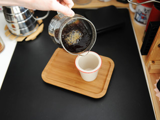 Manual brewing still life. Pouring filter coffee from glass jug into cup. Bamboo tray. Third wave speialty aesthetics