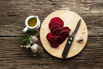 Beetroot Chips. Healthy handmade vegetable chips. On a cutting board, pieces of root vegetables. Garlic and oregano spices for the dish. Olive oil and salt are used in the preparation. Soft focus