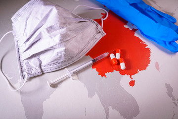 N95 respirator mask, syringe and pills over a China map. Medical and coronavirus concepts