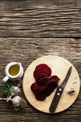 Beetroot Chips. Healthy handmade vegetable chips. On a cutting board, pieces of root vegetables. Garlic and oregano spices for the dish. Olive oil and salt are used in the preparation. Soft focus