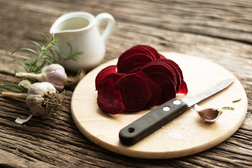 Beetroot Chips. Healthy handmade vegetable chips. On a cutting board, pieces of root vegetables. Garlic and oregano spices for the dish. Olive oil and salt are used in the preparation. Soft focus