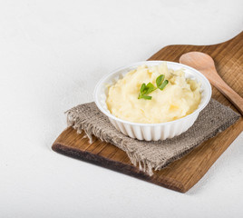 Mashed potatoes with greens on a light background in rustic style