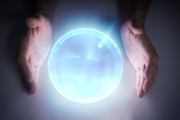 Magician or fortune teller is predicting future with crystal sphere.