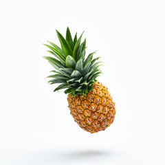 Flying in air pineapple tropical fruit isolated on white. Juicy healthy vitamin pineapple, vegan food. Organic whole sweet fresh fruits. Levitation, falling pineapple creative concept