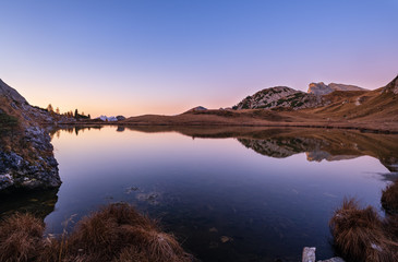 Early morning autumn alpine Dolomites mountain scene. Peaceful Valparola Path and Lake view, Belluno, Italy.