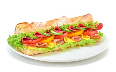 Fresh submarine sandwich on plate with ham, cheese, salami, tomato, lettuce salad, cucumber isolated on white. Colorful tasty baguette homemade large sub sandwich with vegetables. Fast food concept
