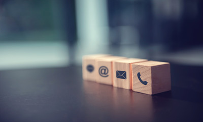 Contact us concept, Wood block symbol telephone, mail, and address on desk.