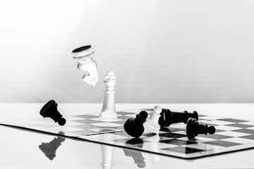 Spielfiguren auf einem Schachbrett fallen um