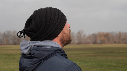 Portrait Of An Attractive Man With A Beard In A Knitted Hat. Hipster In A Hat