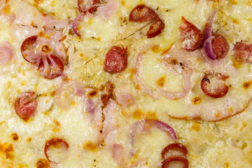 Texture of a delicious fresh pizza with sausage, red onion and cheese