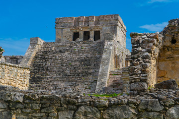 Ruins of ancient Tulum. Architecture of ancient maya. View with temple and other old buildings, houses. Blue sky and lush greenery of nature. travel photo. Wallpaper or background. Yucatan. Mexico.